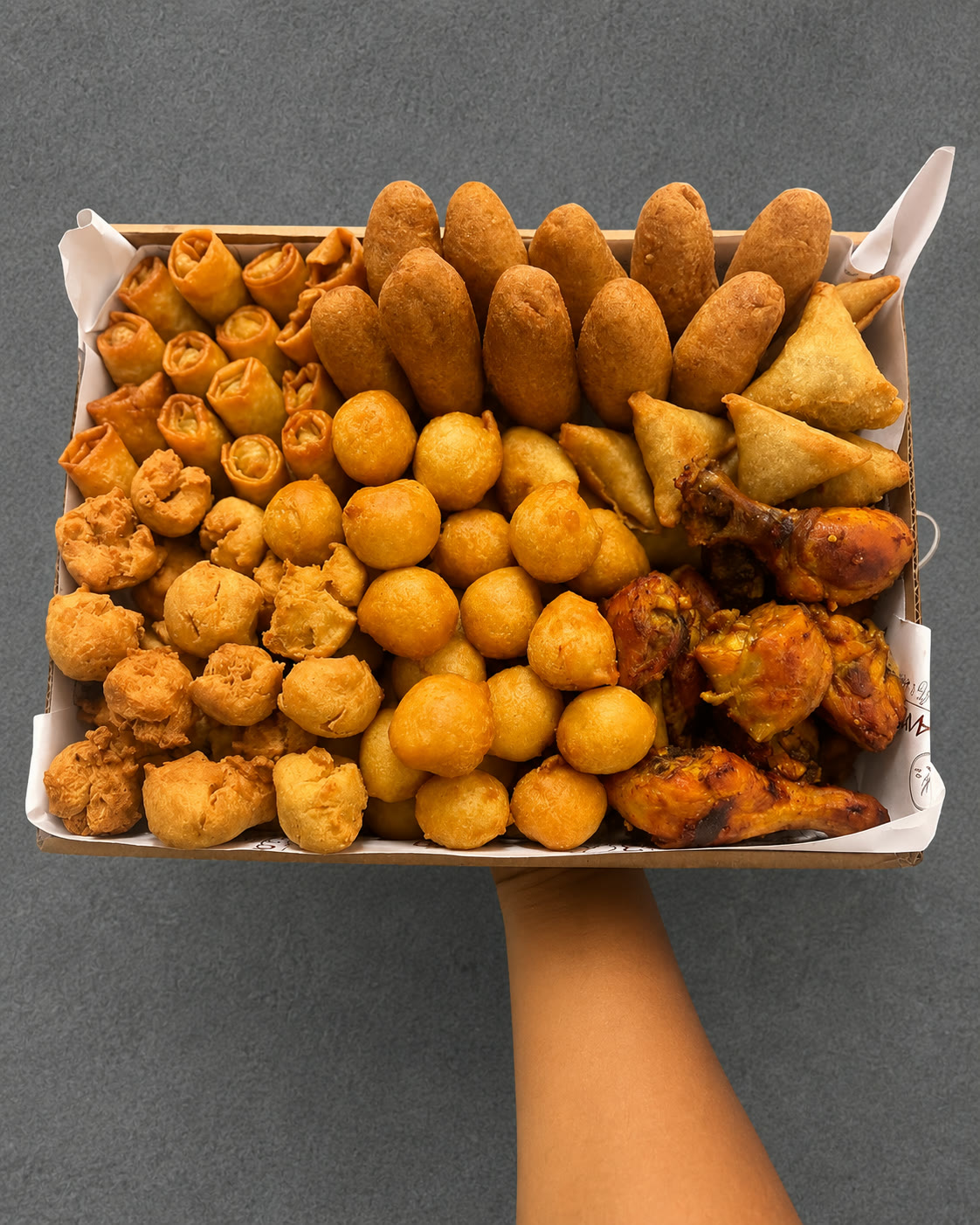 Small chops tray with puff puff, samosa, spring rolls and chicken